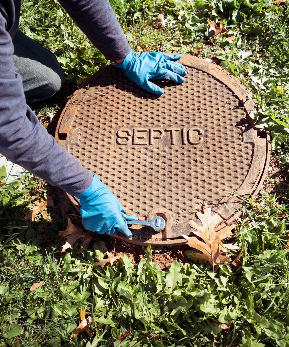 Septic tank cover with man opening it up.